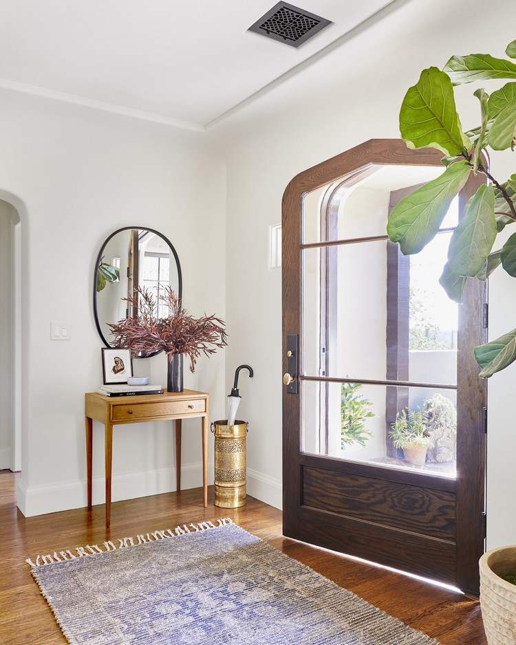 Design the hallway in vintage style with a side table and round mirror