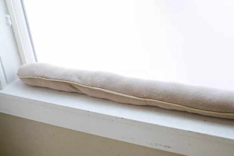 Use a purchased or homemade draft excluder to insulate windows and store heat in the room