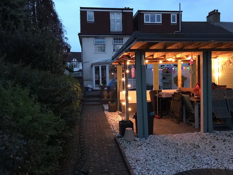 Cozy patio area with pergola and matching light sources for subtle outdoor lighting